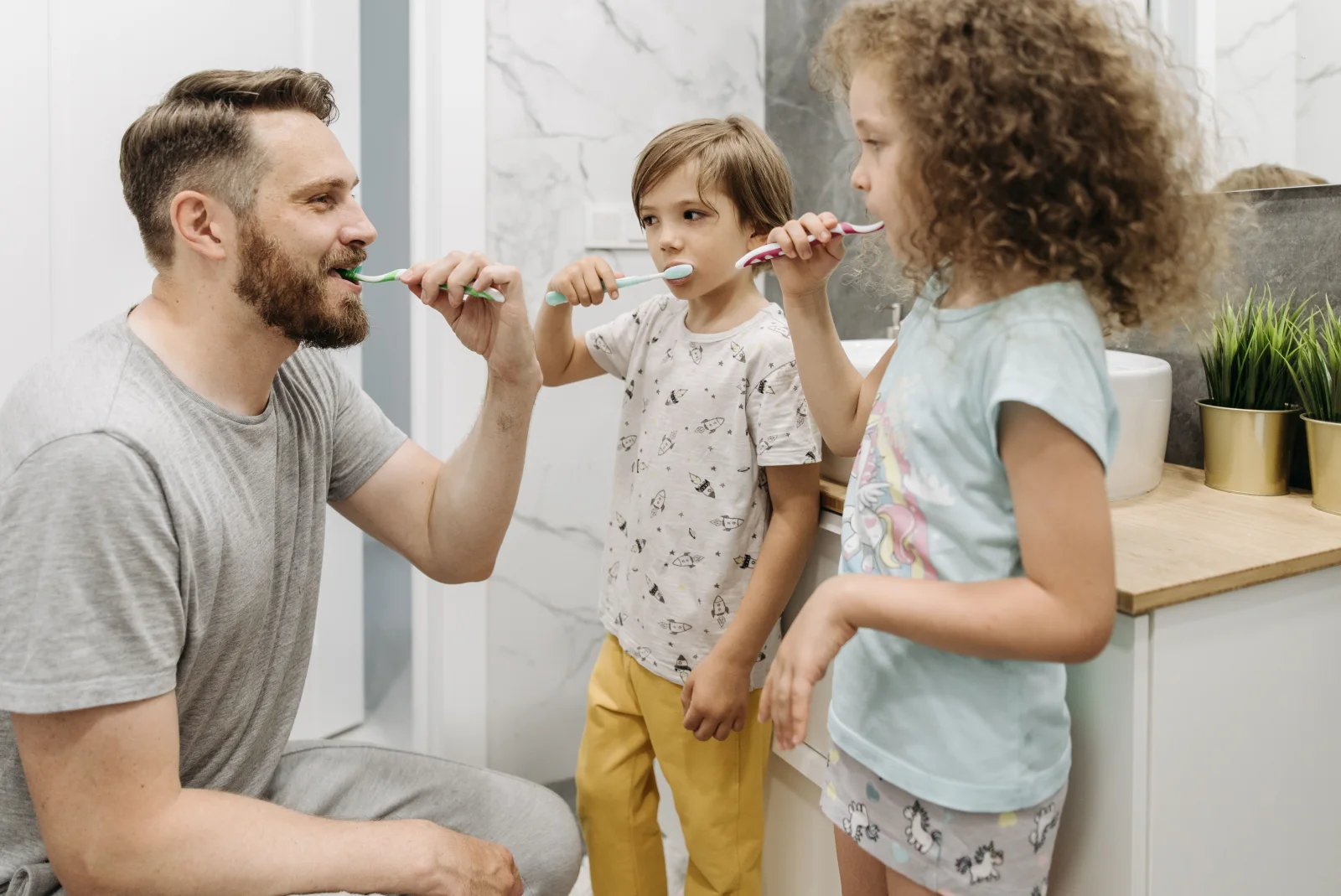 Family brushing teeth together for children’s dentistry information