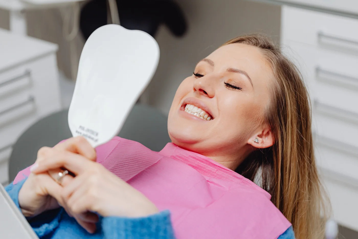 Person in a dental chair viewing a shade guide for crowns and bridges information